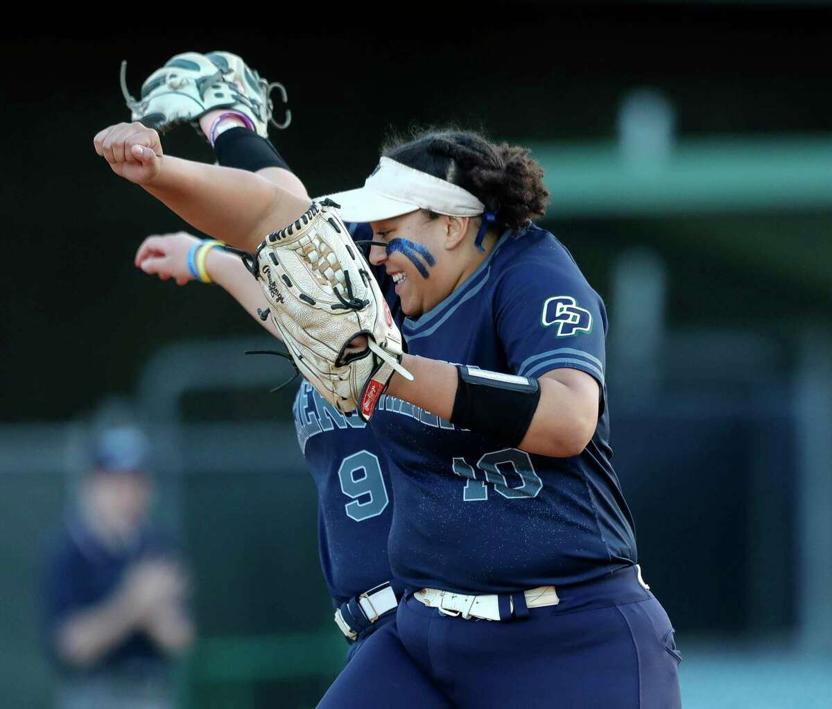 College Park third baseman Jennifer Battiste (10) leaps up with shortstop Ava McCracken (9) after fielding back-to-back fly balls during a District 13-6A high school softball game at College Park High School, Friday, April 8, 2022, in The Woodlands.