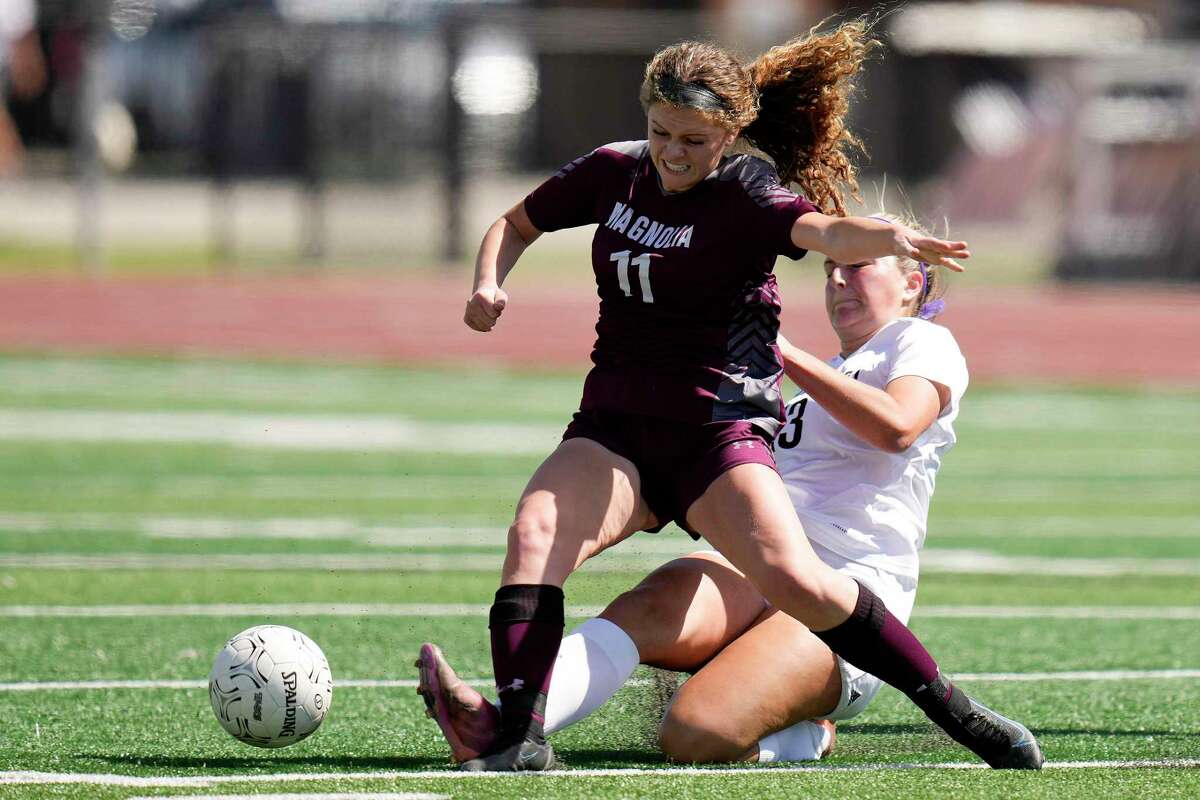 Magnolia's Michelle Polo (11) moves the ball as Friendswood's Emma Saldana tries to tackle during the first half of the Region III-5A girls soccer championship Saturday in Humble.