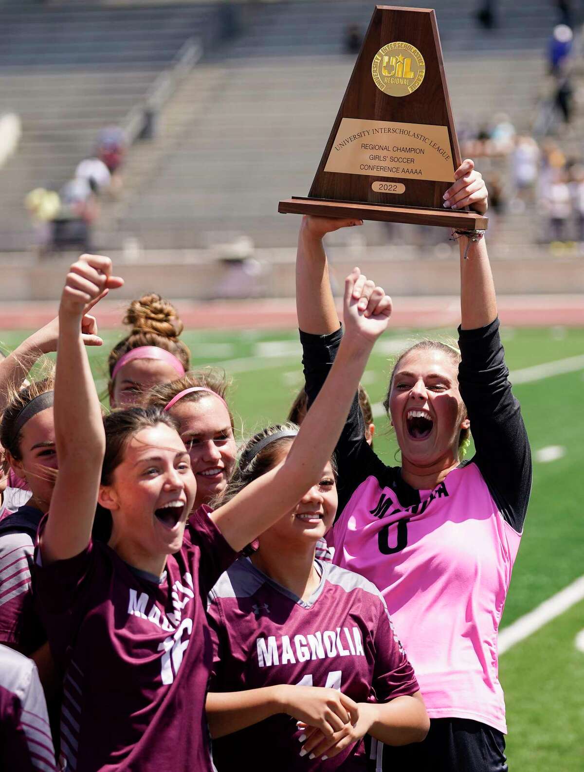 Magnolia's Taylor Sanderson, right, lifts the champions’ trophy after the teams’s win over Friendswood's in the Region III-5A final high school soccer playoff game, Saturday, April 9, 2022, in Humble, TX.