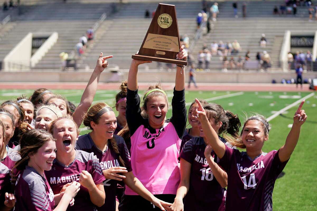 Magnolia's Taylor Sanderson, center, lifts the champions’ trophy after the teams’s win over Friendswood's in the Region III-5A final high school soccer playoff game, Saturday, April 9, 2022, in Humble, TX.