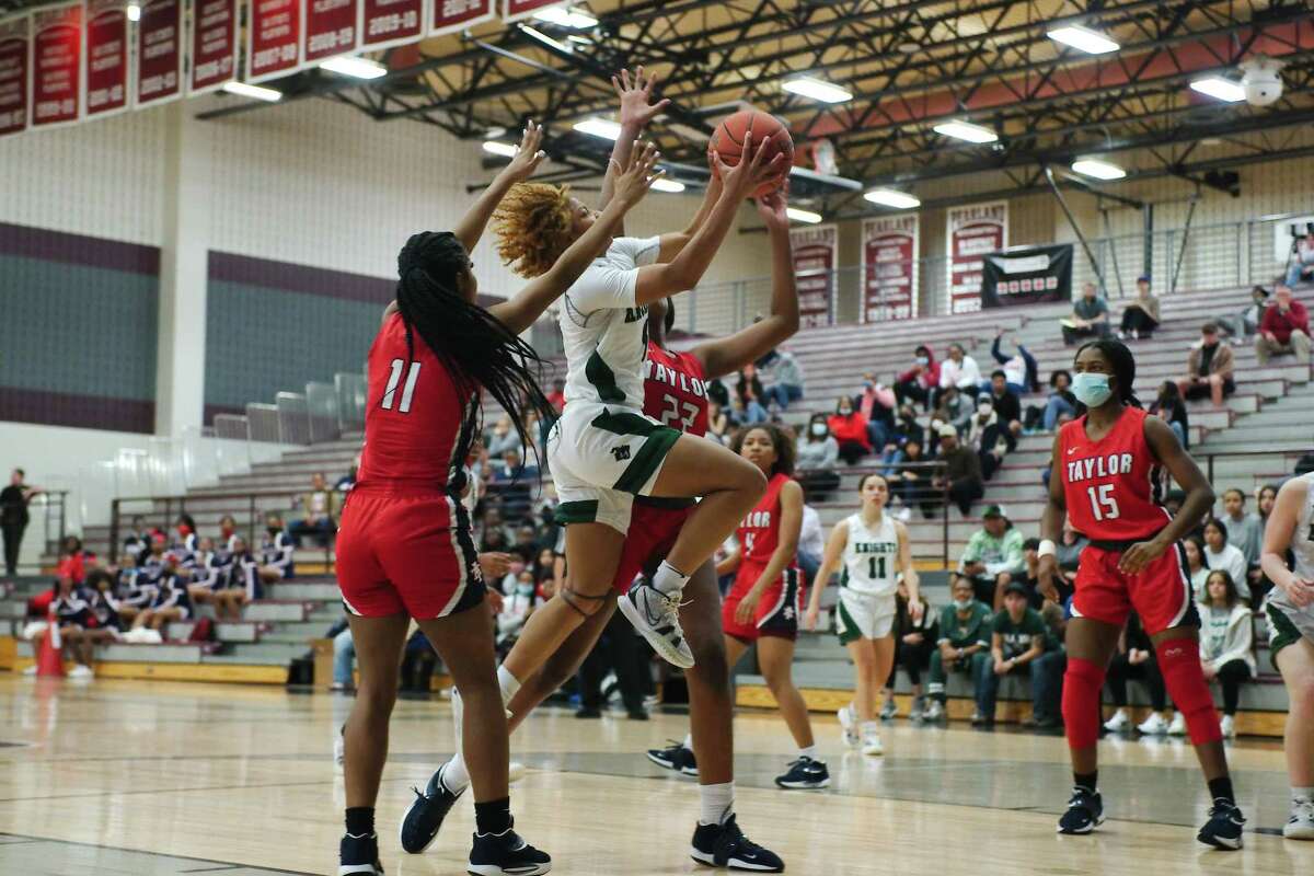 Clear Falls’ Samora Watson (5) drives to the basket past Alief Taylor’s Alyssa Prier (11) and Alief Taylor’s Nataliyah Gray (22) Tuesday, Feb. 15, 2022 at Pearland High School.