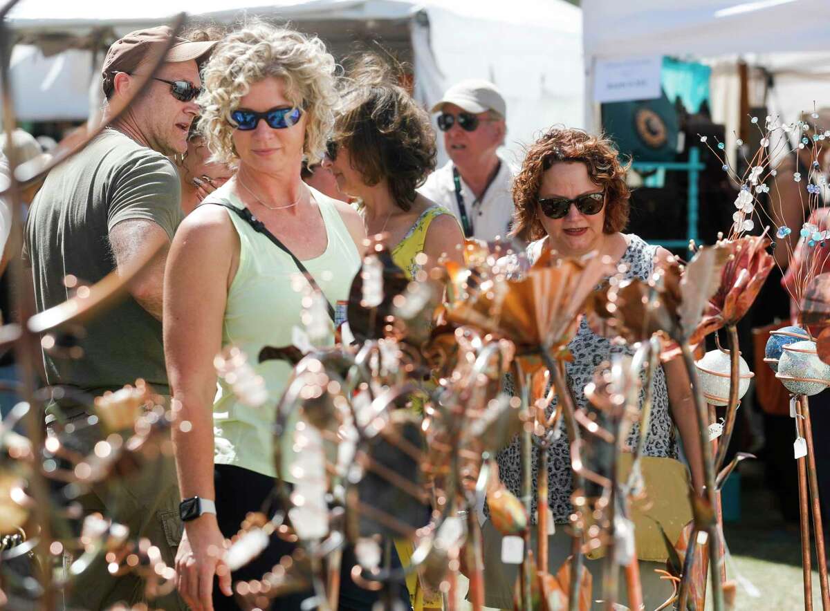 Guests look over metal sculptures during The Woodlands Waterway Arts Festival at Town Green Park, Saturday, April 9, 2022, in The Woodlands.