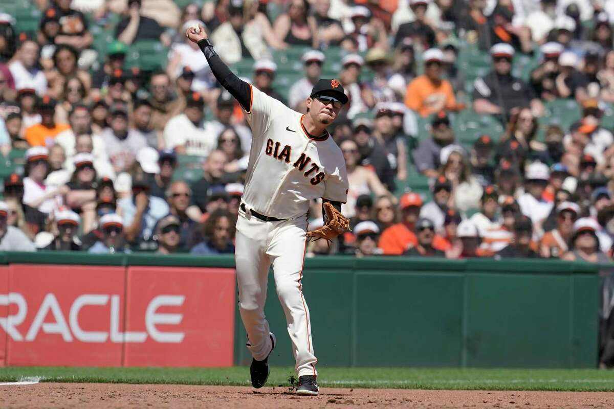 San Francisco Giants third baseman Wilmer Flores commits a throwing error after fielding a base hit by Miami Marlins' Jon Berti during the third inning of a baseball game in San Francisco, Saturday, April 9, 2022. (AP Photo/Jeff Chiu)