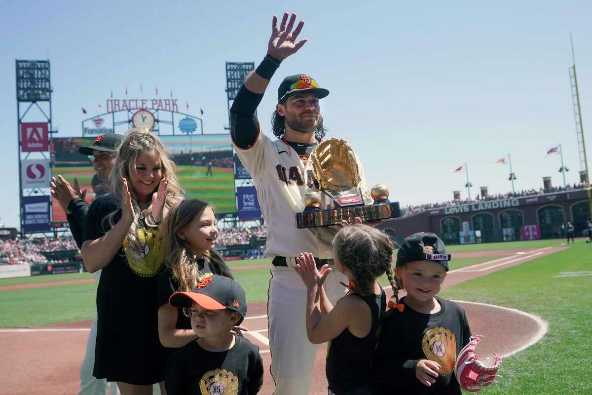 San Francisco Giants shortstop Brandon Crawford, middle, waves with family after receiving the Gold Glove Award before a baseball game between the Giants and the Miami Marlins in San Francisco, Saturday, April 9, 2022. (AP Photo/Jeff Chiu)