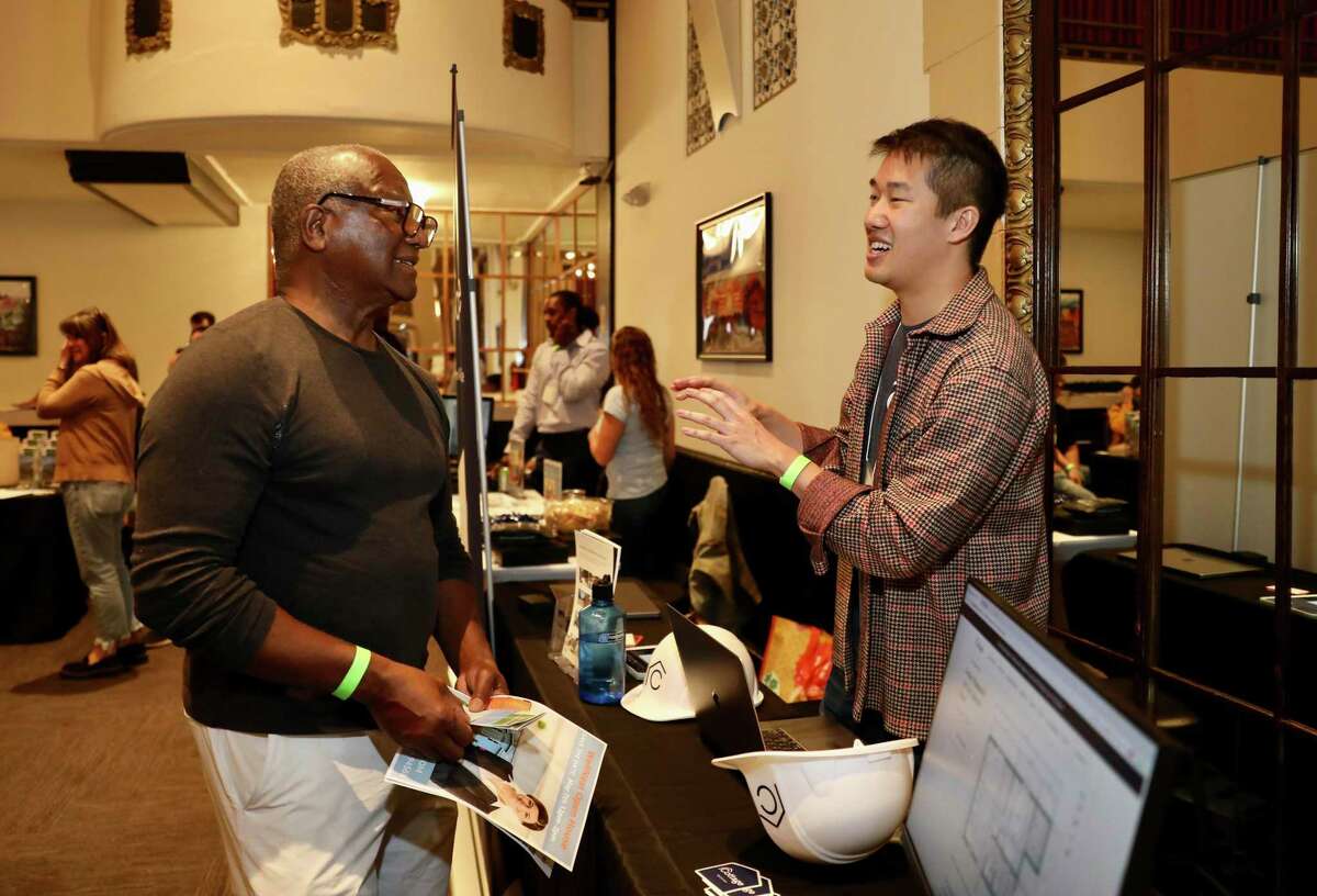 Russell Prince, 73, left, converses with Kevin Chen, head of growth at Cottage, a builder that uses technology to reimagine residential construction, during a workshop for homeowners looking to build accessory dwelling units (ADUs) on their properties held at the California Ballroom on Saturday, April 9, 2022, in Oakland. Prince, who buys and sells houses, is talking to his Oakland-based daughter about ADUs since she owns property. “It just adds value,” he said.