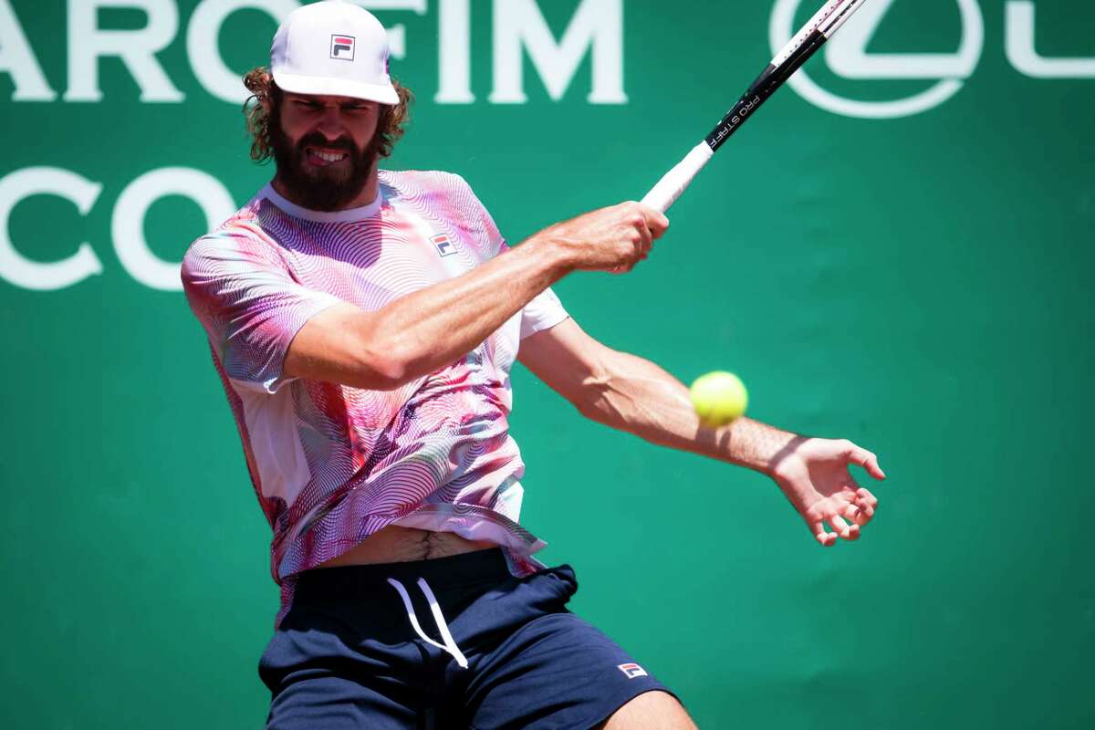 Reilly Opelka, of the USA, returns Nick Kyrgios, of Australia, serve in the men’s singles semifinal of the Fayez Sarofim & Co. U.S. Men's Clay Court Championships at River Oaks Country Club, Saturday, Apr 9, 2022, in Houston.
