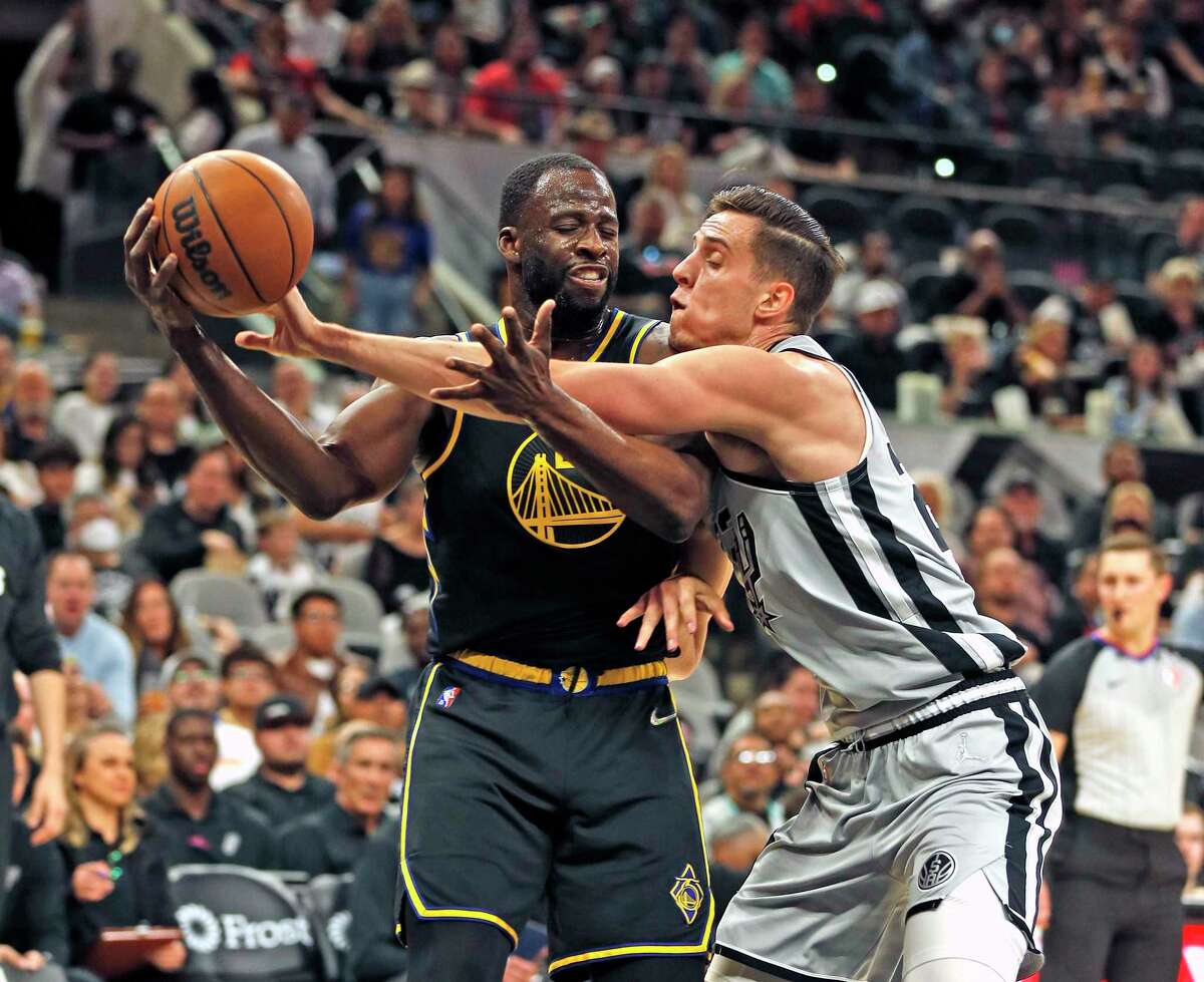 SAN ANTONIO, TX - APRIL 9: Draymond Green #23 of the Golden State Warriors grabs a rebound against Zach Collins #23 of the San Antonio Spurs in the first half at AT&T Center on April 9, 2022 in San Antonio, Texas. NOTE TO USER: User expressly acknowledges and agrees that, by downloading and or using this photograph, User is consenting to terms and conditions of the Getty Images License Agreement. (Photo by Ronald Cortes/Getty Images)