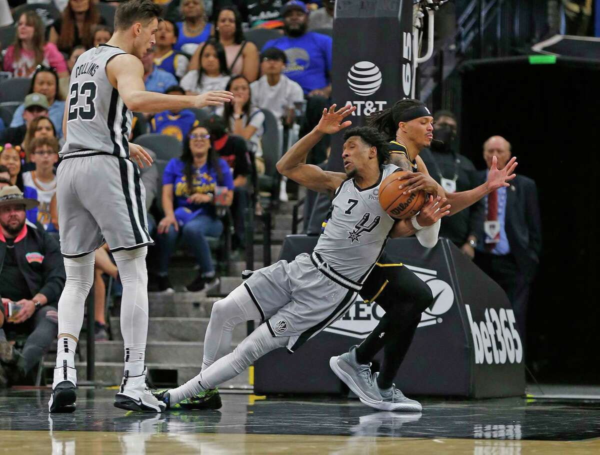 Josh Richardson (7) of the Spurs steals the ball from Damion Lee of the Golden State Warriors in the first half at AT&T Center on April 9, 2022 in San Antonio.