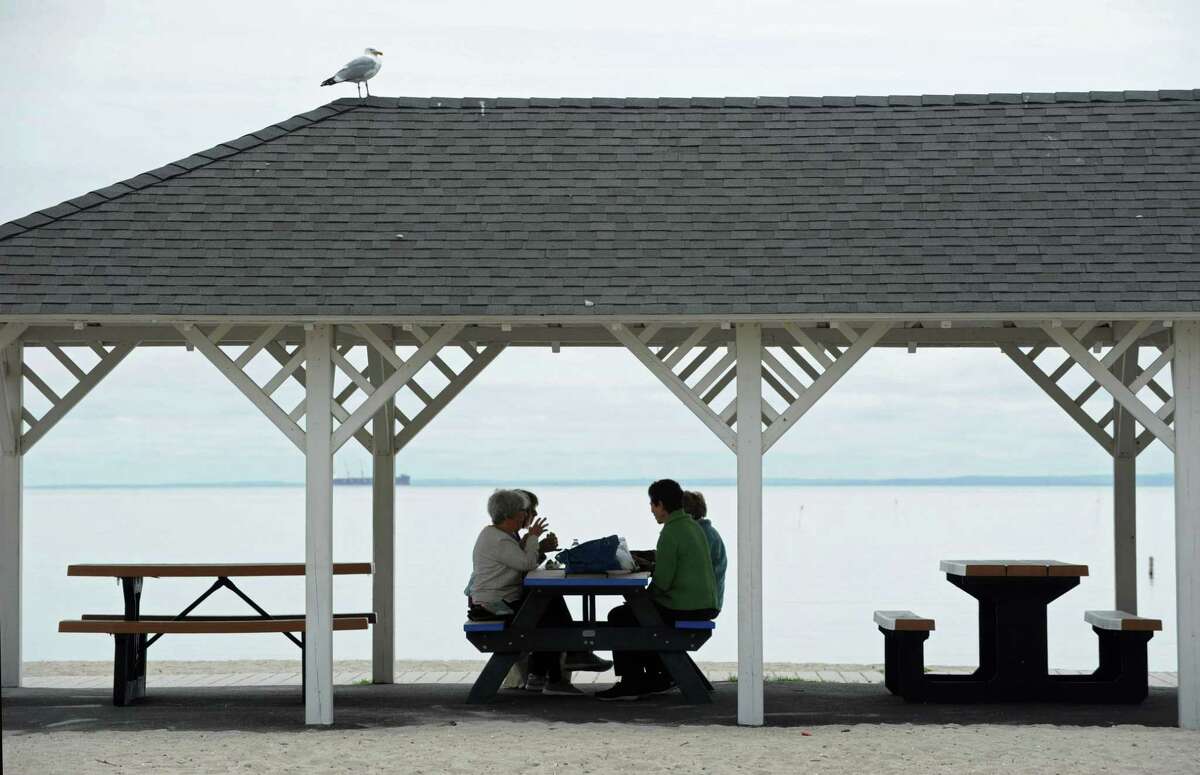 Beachgoers have lunch under the pavillion and partly cloudy skies at Compo Beach Thursday, May 10, 2018, in Westport, Conn.