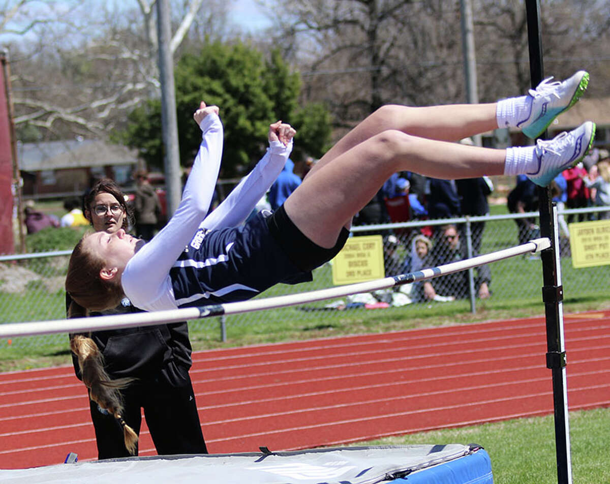Father McGivney's Mia Range leaps over the bar in the high jump at the East Alton-Wood River Invitational on Saturday.