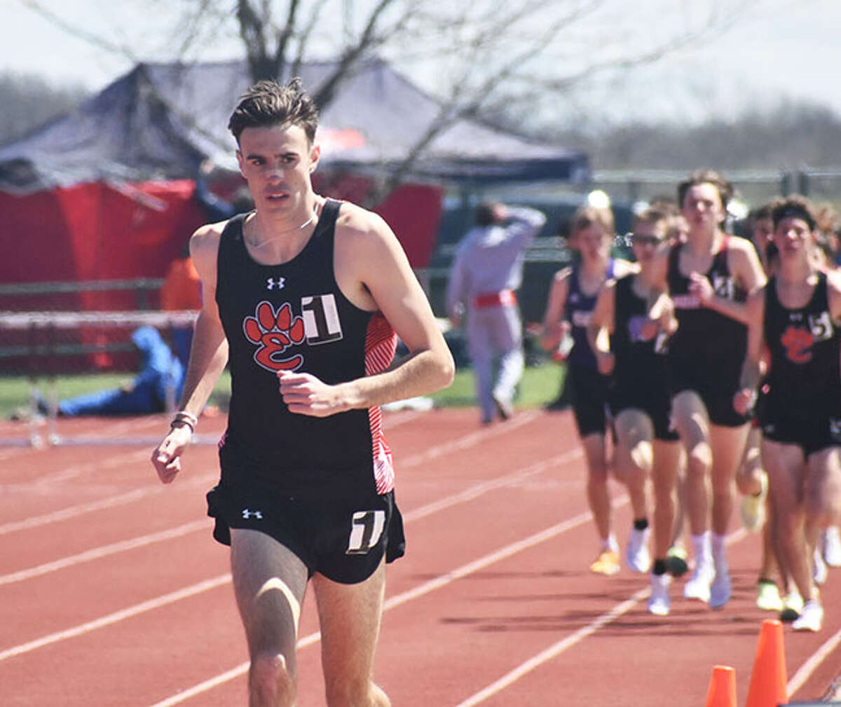 Edwardsville's Ryan Watts (left) looks to the clock during his record-setting 3,200-meter run at the Norm Armstrong Invitational at Belleville West on Saturday in Belleville.