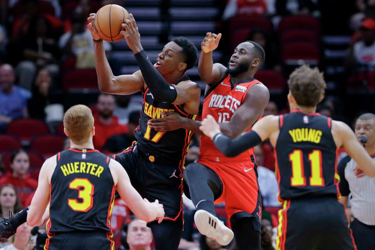 Atlanta Hawks forward Onyeka Okongwu (17) pulls in a rebound in front of Houston Rockets forward Usman Garuba, center right, as guards Kevin Huerter (3) and Trae Young (11) look on during the first half of an NBA basketball game, Sunday, April 10, 2022, in Houston. (AP Photo/Michael Wyke)