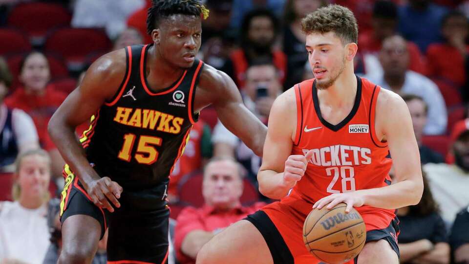 Atlanta Hawks center Clint Capela (15) defends as Houston Rockets center Alperen Sengun (28) attempts to drive to the basket during the first half of an NBA basketball game, Sunday, April 10, 2022, in Houston. (AP Photo/Michael Wyke)