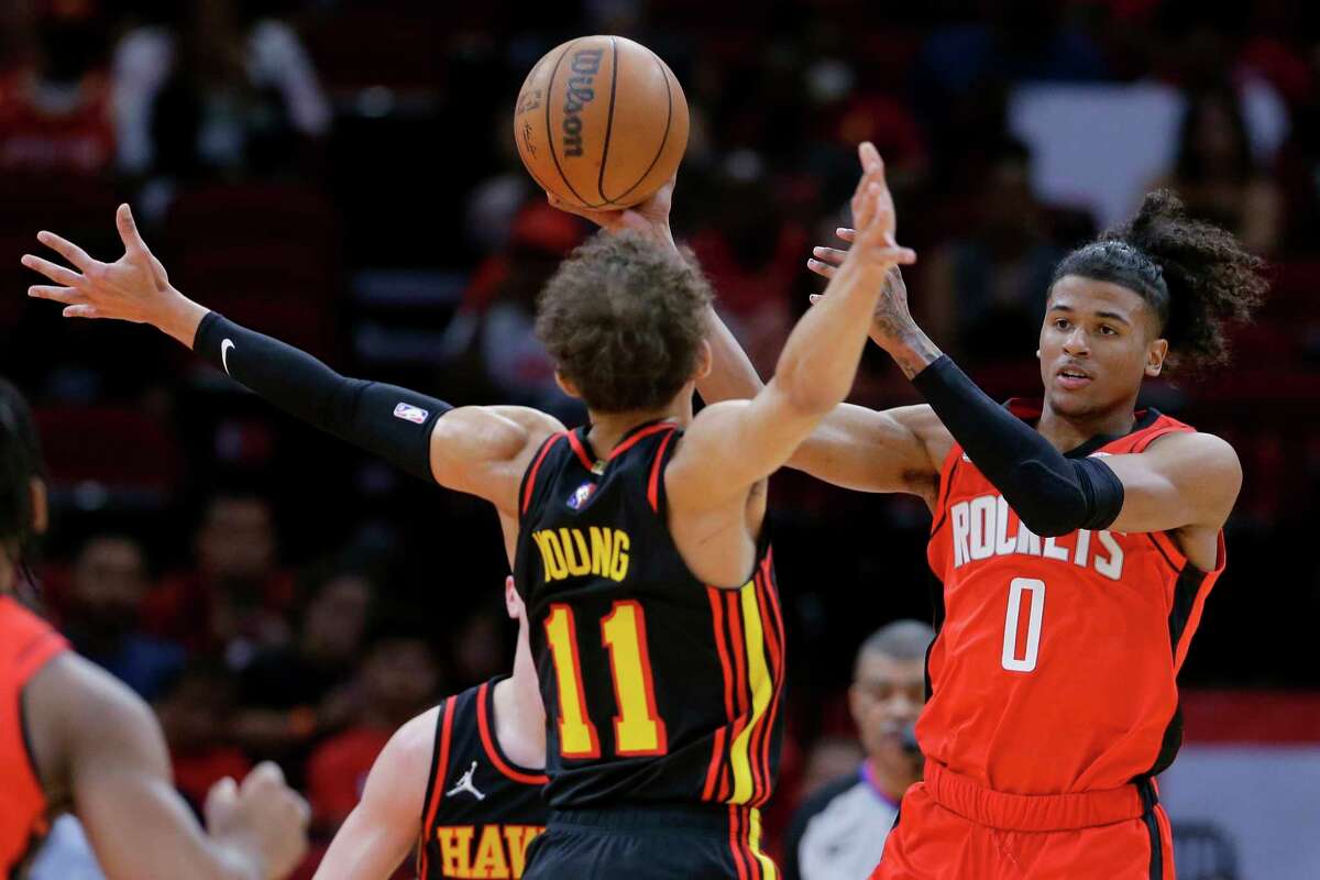 Houston Rockets guard Jalen Green (0) passes the ball as Atlanta Hawks guard Trae Young (11) defends during the first half of an NBA basketball game, Sunday, April 10, 2022, in Houston. (AP Photo/Michael Wyke)