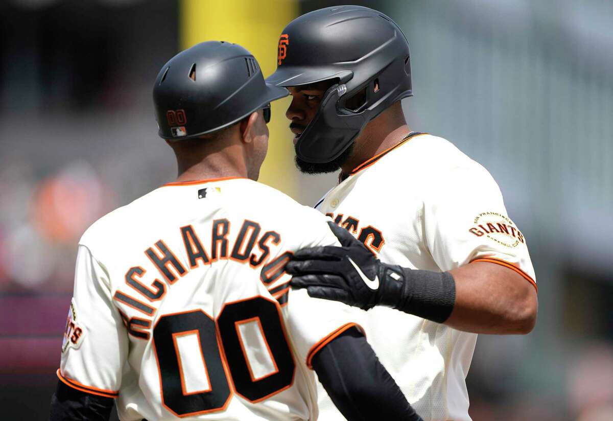 SAN FRANCISCO, CALIFORNIA - APRIL 10: Heliot Ramos #53 of the San Francisco Giants is congratulated by first base coach Antoan Richardson #00 after Ramos got his first career hit in his major league debut against the Miami Marlins in the bottom of the second inning at Oracle Park on April 10, 2022 in San Francisco, California. (Photo by Thearon W. Henderson/Getty Images)