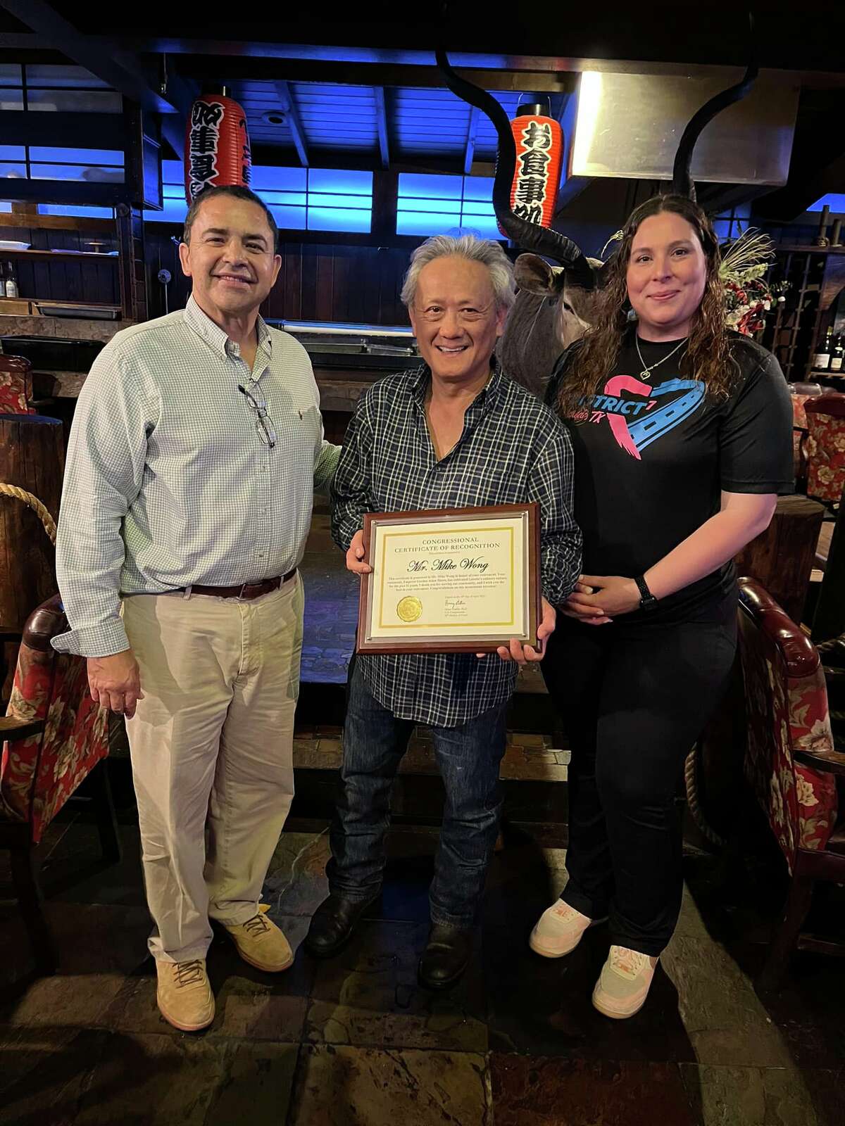 Emperor Garden Asian Bistro's owner Michael Wong, center, is pictured on the final day of his establishment being open as he retires after 31 years on April 10, 2022. He is pictured with a plaque next to Rep. Henry Cuellar and District VII Councilmember Vanessa Perez.