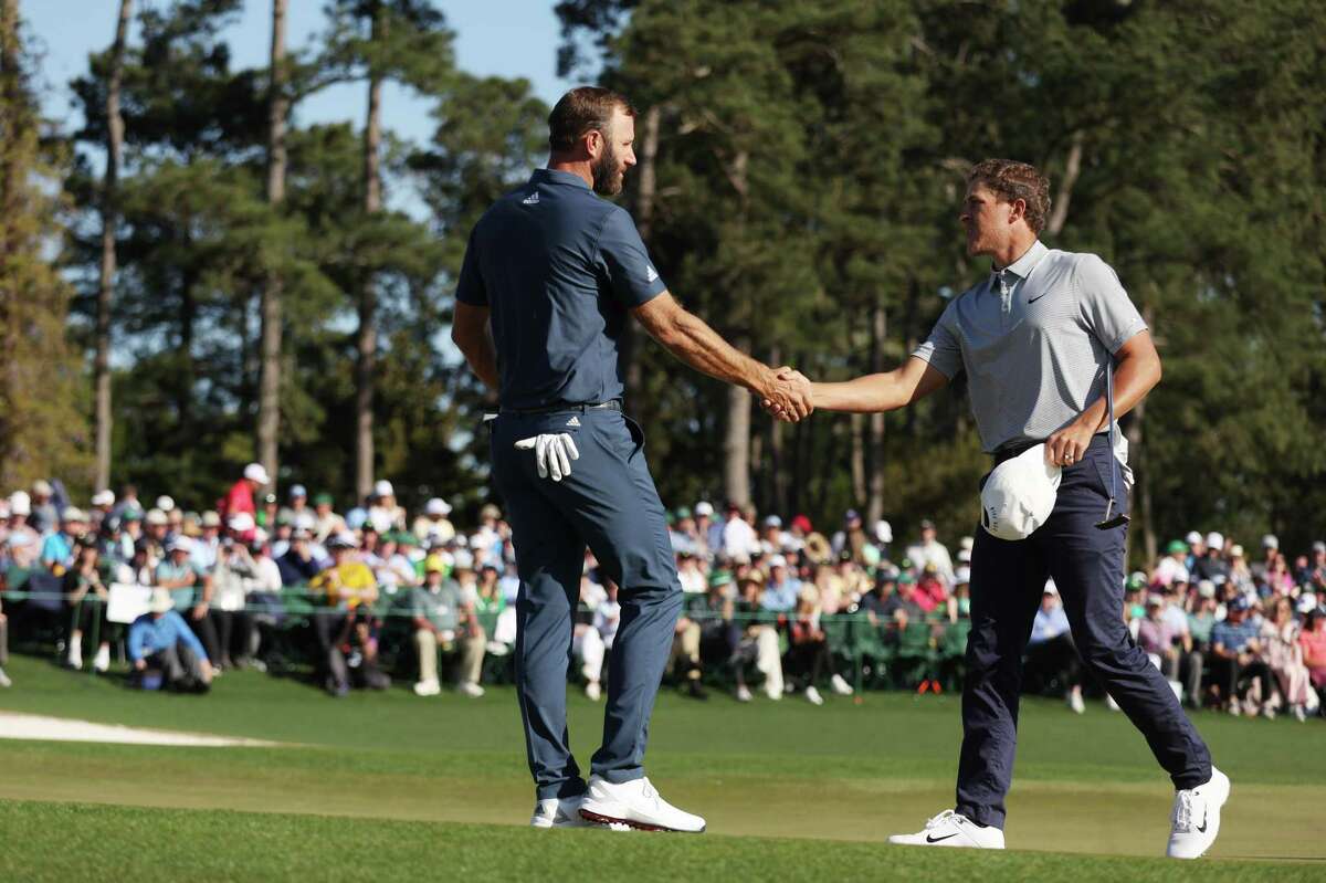 AUGUSTA, GEORGIA - APRIL 10: Dustin Johnson (L) and Cameron Champ shake hands on the 18th green after finishing their round during the final round of the Masters at Augusta National Golf Club on April 10, 2022 in Augusta, Georgia. (Photo by Jamie Squire/Getty Images)