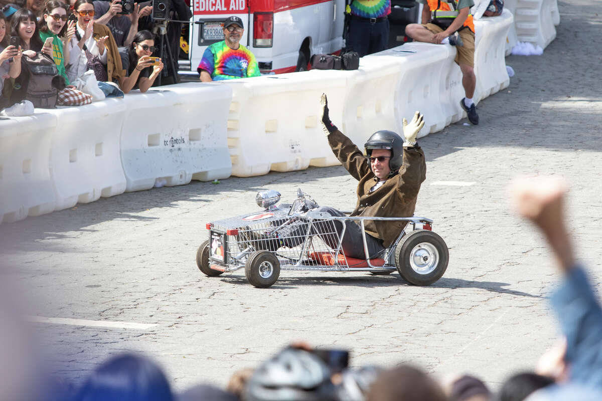 Jason "Geai" Broemmel salue la foule après une course de magasinage réussie dans son chariot de course de caisses à savon Safeway lors du derby de caisses à savon SFMOMA à McLaren Park à San Francisco le 24 avril 2019. 10, 2022.