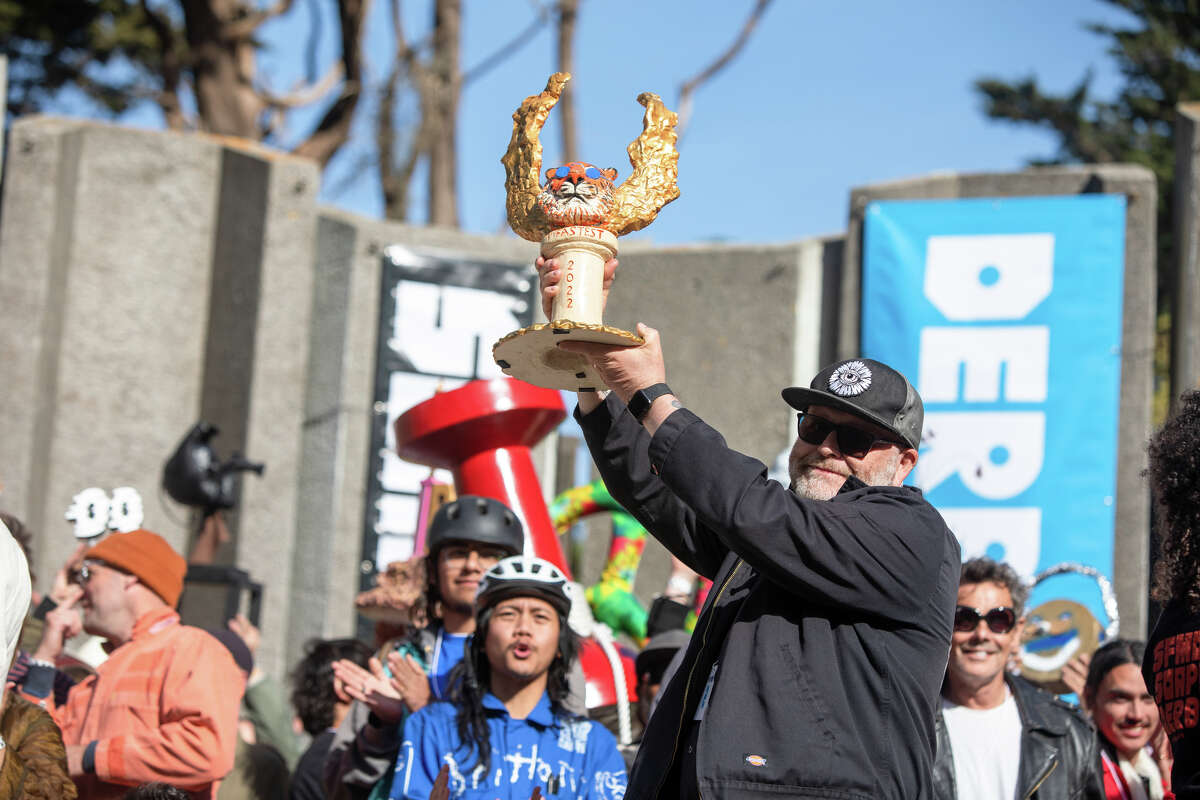 John Case tient le trophée qu'il a remporté après avoir réalisé le temps de course le plus rapide avec son coureur de caisses à savon au SFMOMA Soapbox Derby à McLaren Park à San Francisco le 24 avril.  10, 2022.