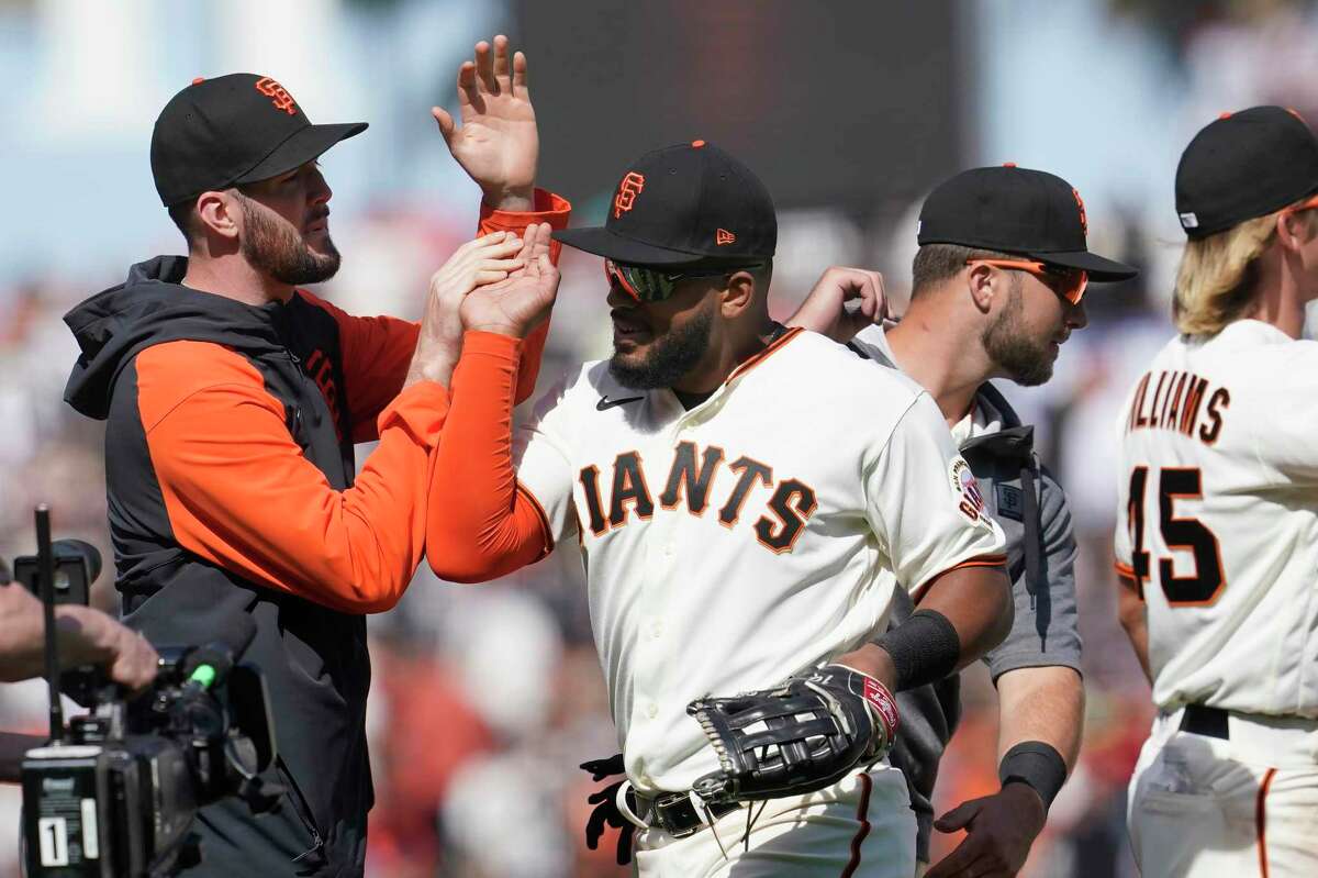 San Francisco Giants pitcher Alex Wood, left, celebrates with left fielder Heliot Ramos after the Giants defeated the Miami Marlins in a baseball game in San Francisco, Sunday, April 10, 2022. (AP Photo/Jeff Chiu)