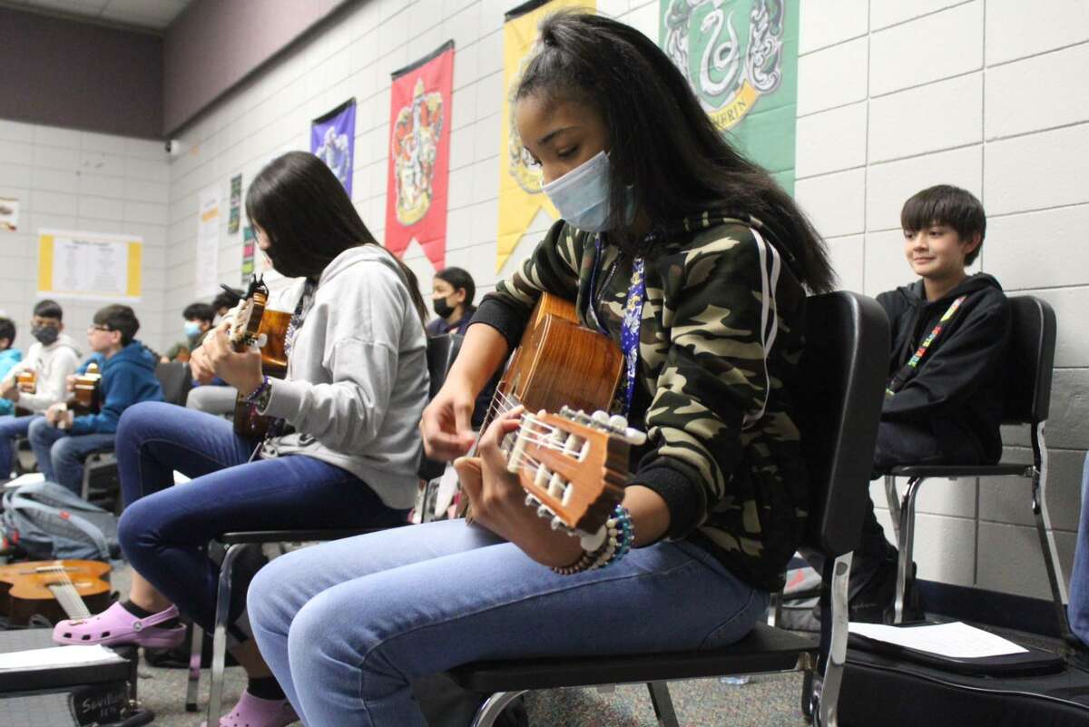 Sterling Middle School student Amiyah Fletcher looking at her music while Ms. Martinez goes over a song.