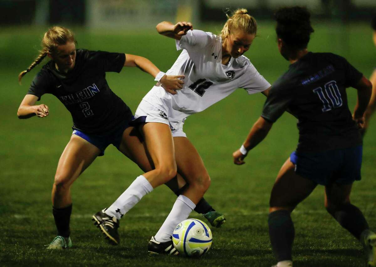 College Park's Carli Rabson (12) battles for position against Klein's Makenzie Blan (2) and Tiana Thompson (10) in the second period of a Region II-6A area high school playoff soccer match, Tuesday, March 29, 2022, in Spring.