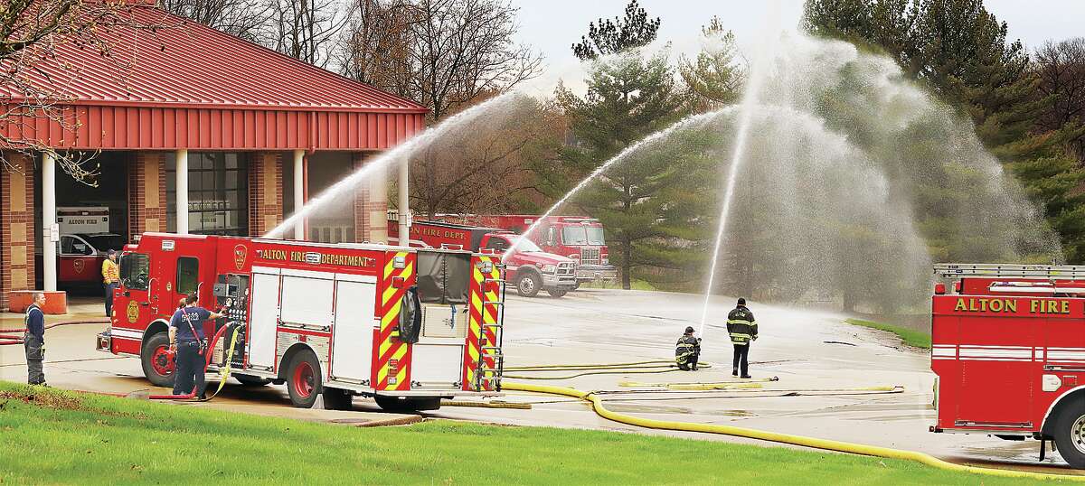 John Badman|The Telegraph Alton fire trucks supply multiple hose lines Monday during pump tactics training at the Don Twitchell Memorial Fire Station.