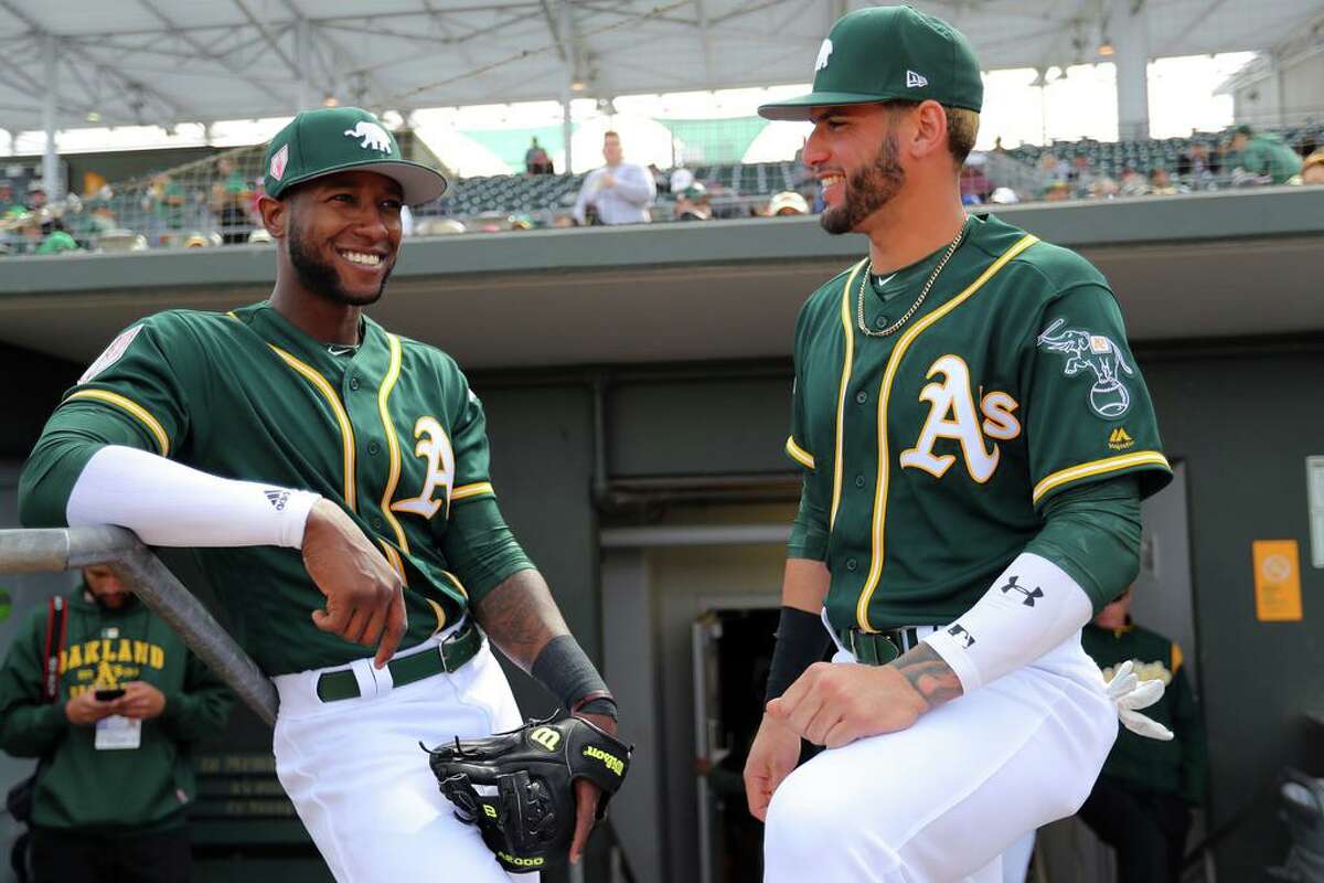 MESA, AZ - FEBRUARY 24: Jurickson Profar #23 speaks with Luis Barrera #79 of the Oakland Athletics in the dugout prior to a Spring Training game against the Kansas City Royals on Sunday, February 24, 2019 at HoHoKam Stadium in Mesa, Arizona. (Photo by Alex Trautwig/MLB Photos via Getty Images)