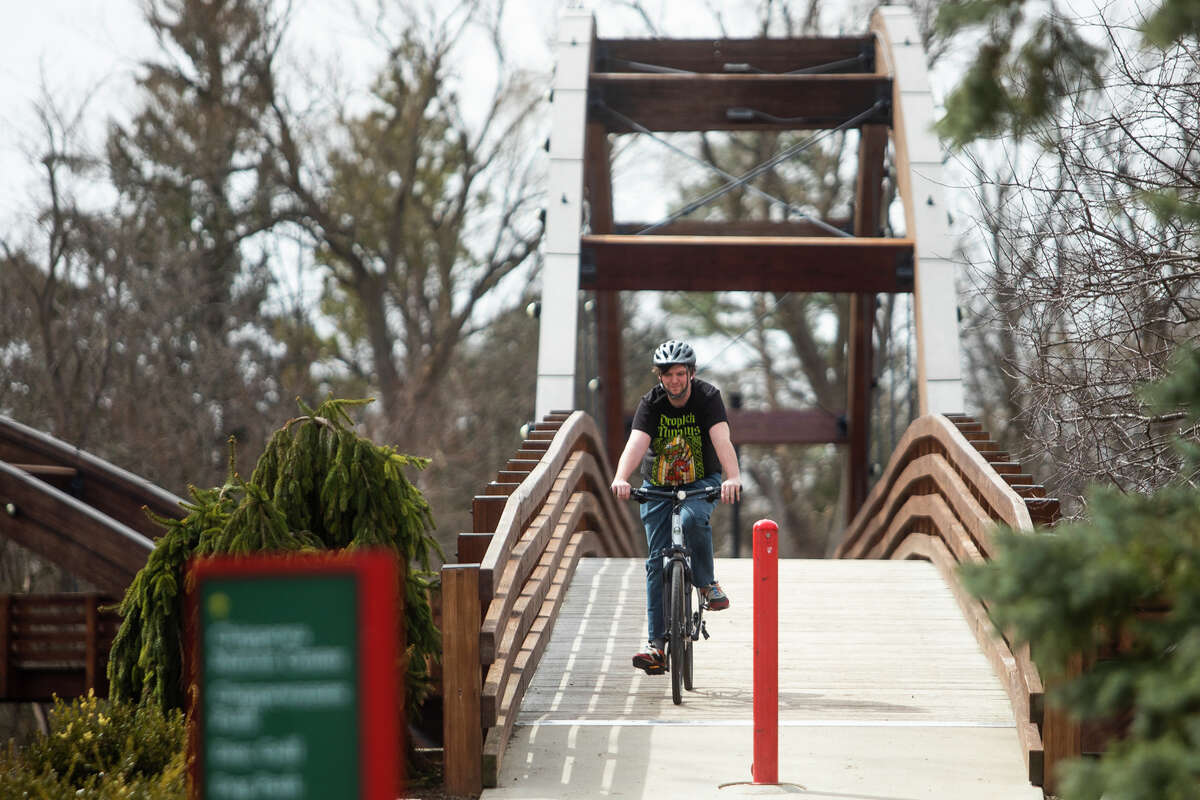 Logan Krause of Bay City rides his bicycle while enjoying temperatures over 60 degrees Monday, April 11, 2022 near the Tridge in Midland.