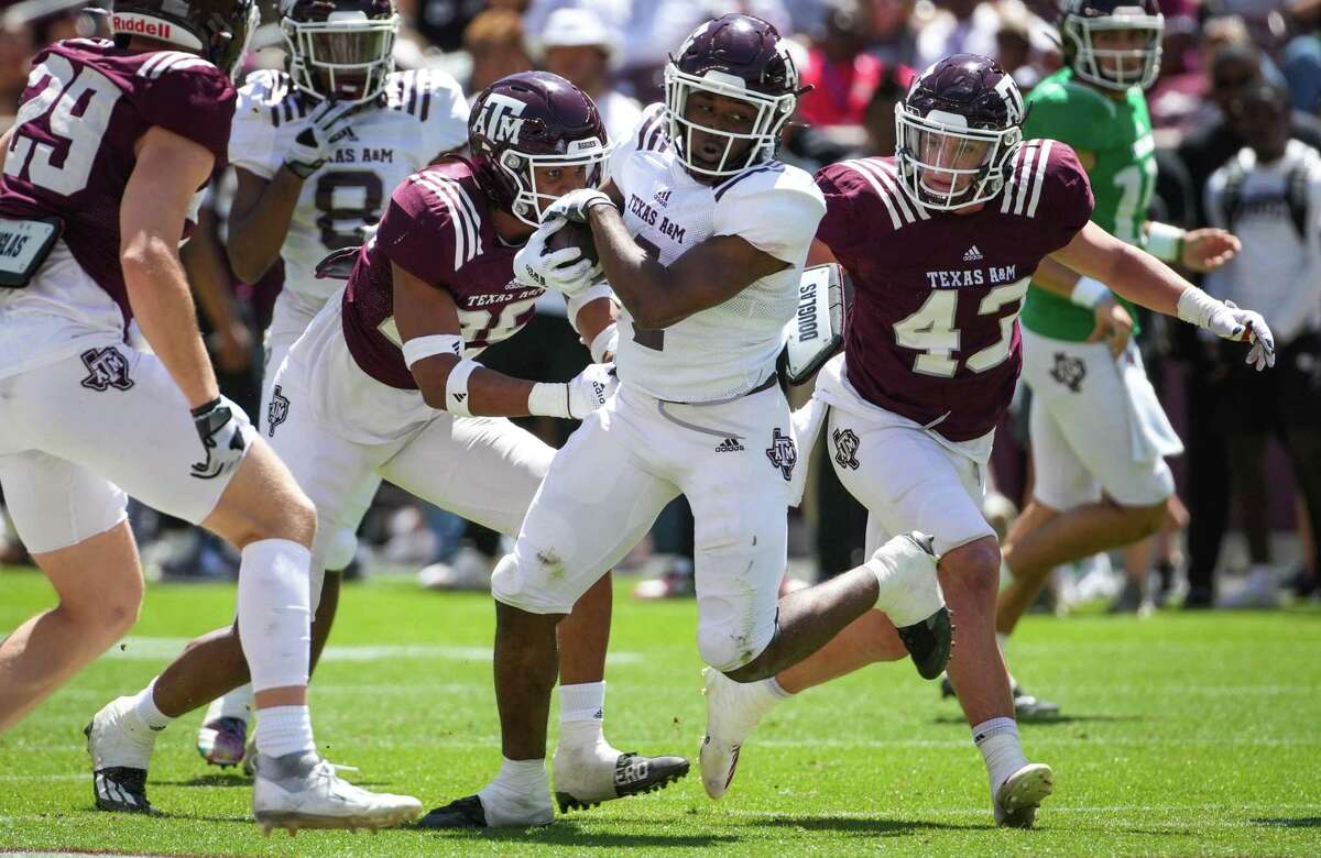 Texas A&M running back Amari Daniels (4) runs the ball against defensive back Alex Zettler during the first half of the annual Maroon and White football game at Kyle Field Saturday, April 9, 2022, in College Station.