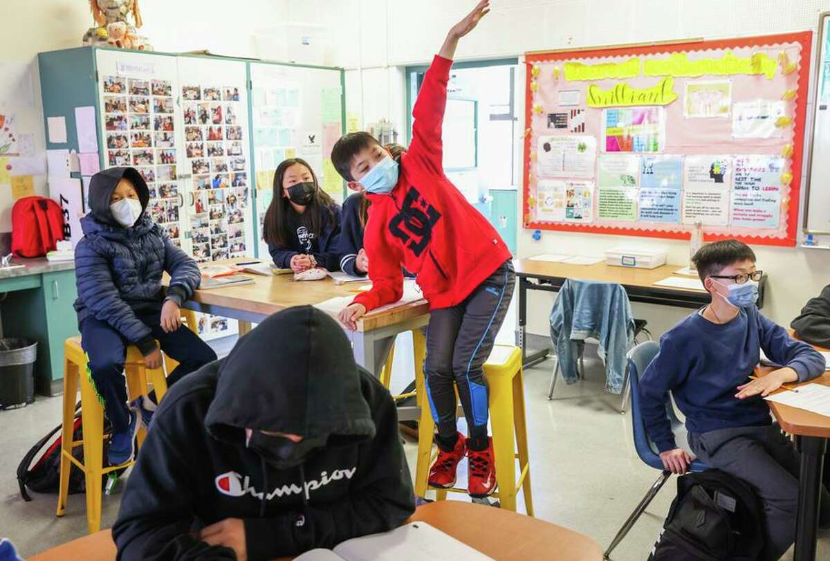 Jaylan Tieu, 11, eagerly raises his hand during math class at San Francisco’s Hoover Middle School.