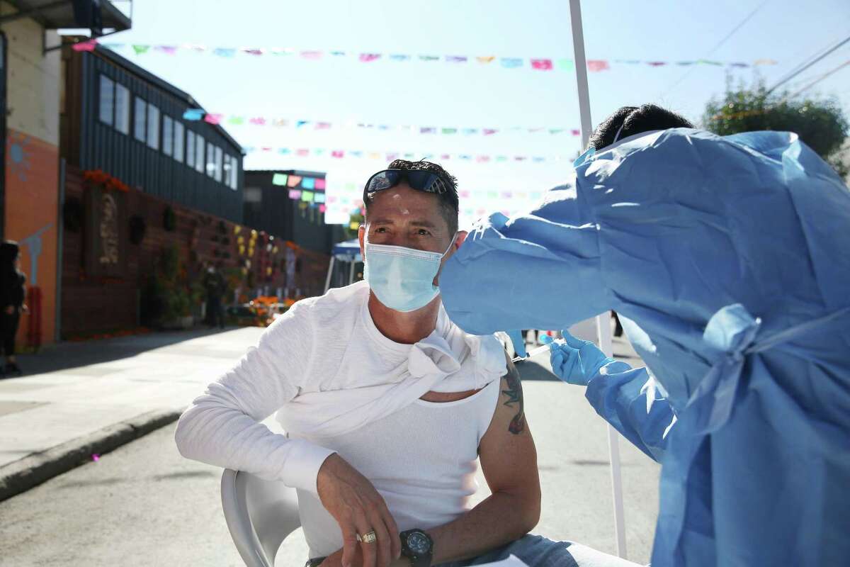 Nurse Po Lin Lui administers a flu shot to Jose Rodriguez at the Latino Task Force Resource Hub in San Francisco in November 2020. Flu cases fell dramatically during the pandemic.