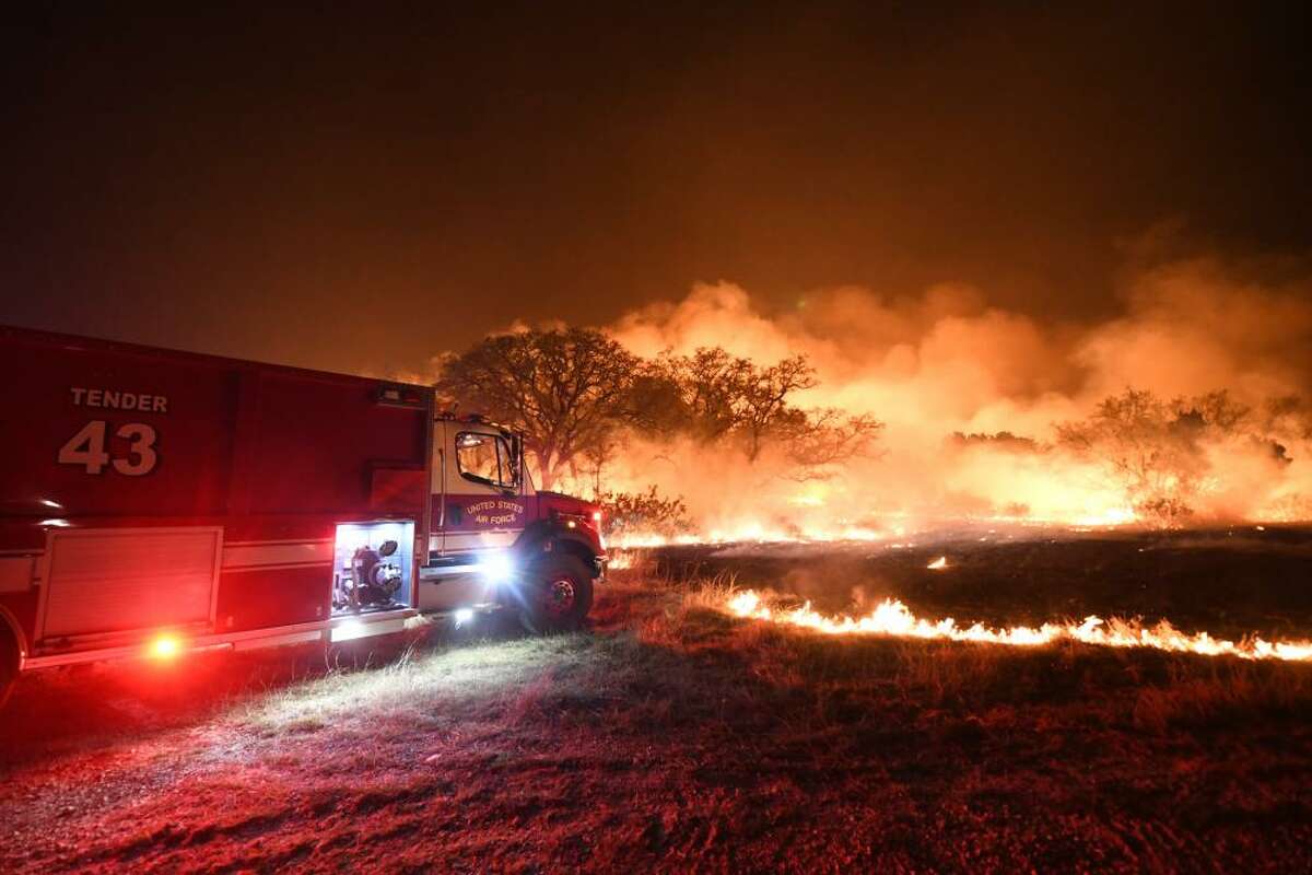 Firefighters battle a wildfire near Joint Base San Antonio-Camp Bullis. The fire started on April 9 near the base. 
