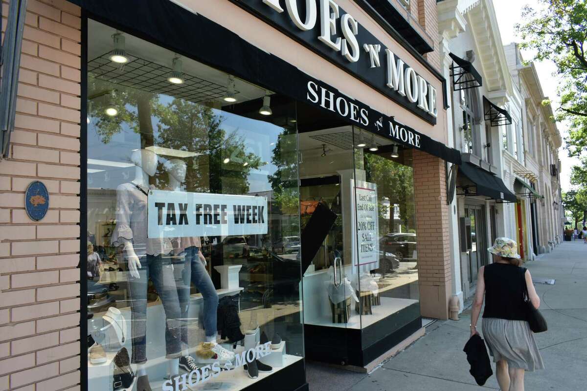 A shopper checks out the window display of Shoes & More on Friday, Aug. 24, 2018, during Connecticut's annual sales tax holiday week that waives sales taxes for many apparel purchases under $100. A similar tax holiday is taking place April 10-16, 2022.