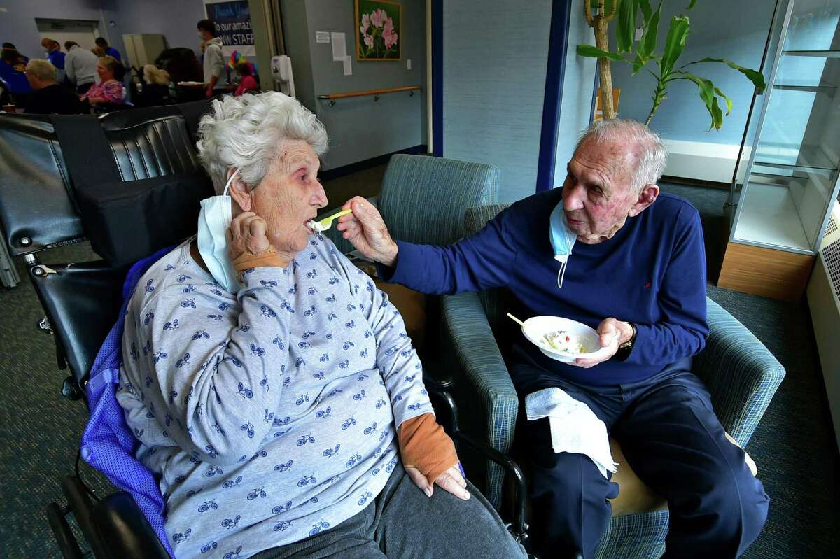 Calvin Darula feeds his wife Lillian some ice cream during an ice cream social held for residents by the Greenwich Rotary Club at The Nathaniel Witherell senior care facility in Greenwich, Conn., on Saturday April 9, 2022. The Rotary Club held the event as part of its Day of Service for Connecticut and Western Massachusetts.