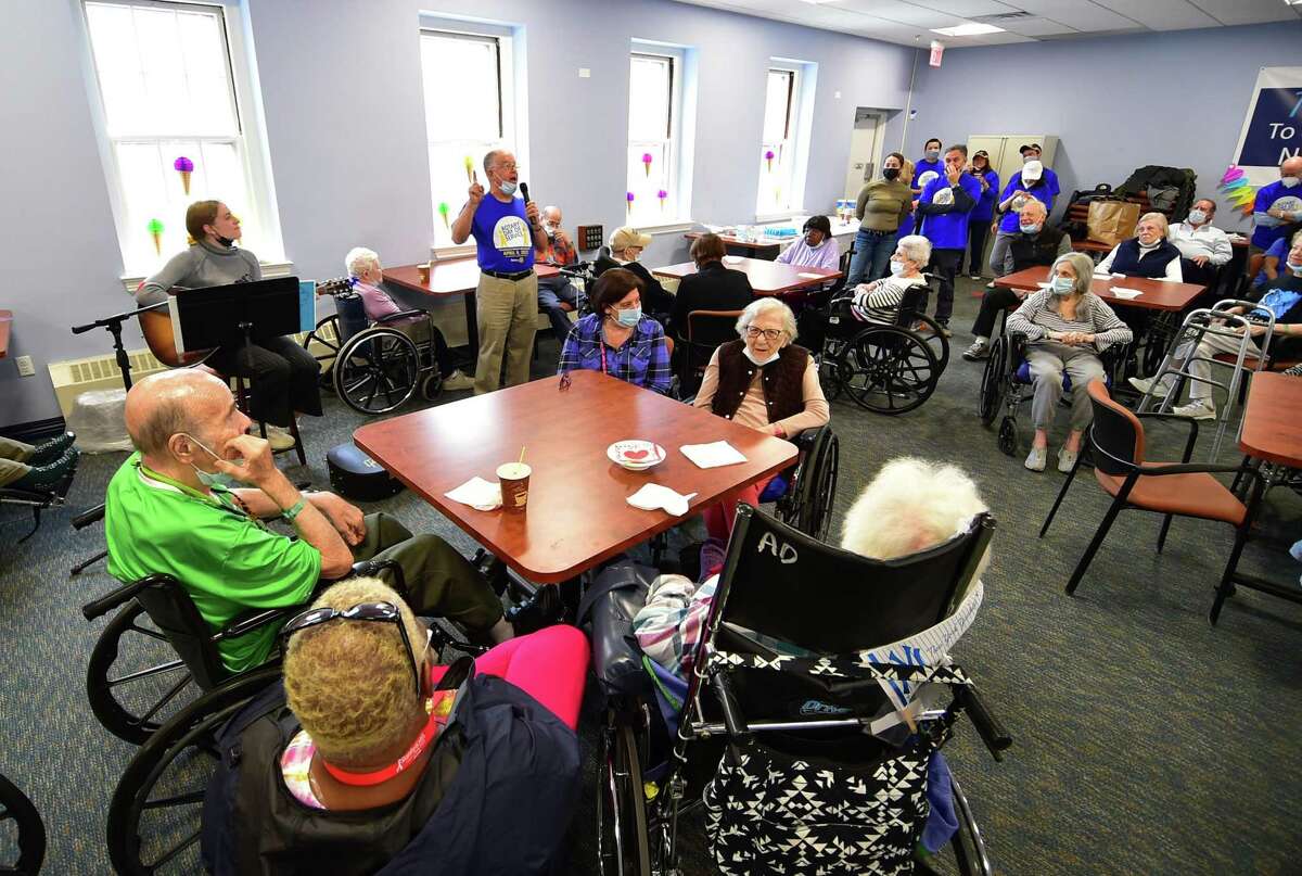 Greenwich Rotary Club's Steve DeLuca leads seniors in a singalong during an ice cream social for residents at The Nathaniel Witherell senior care facility in Greenwich, Conn., on Saturday April 9, 2022. The Rotary Club held the event as part of its Day of Service for Connecticut and Western Massachusetts.