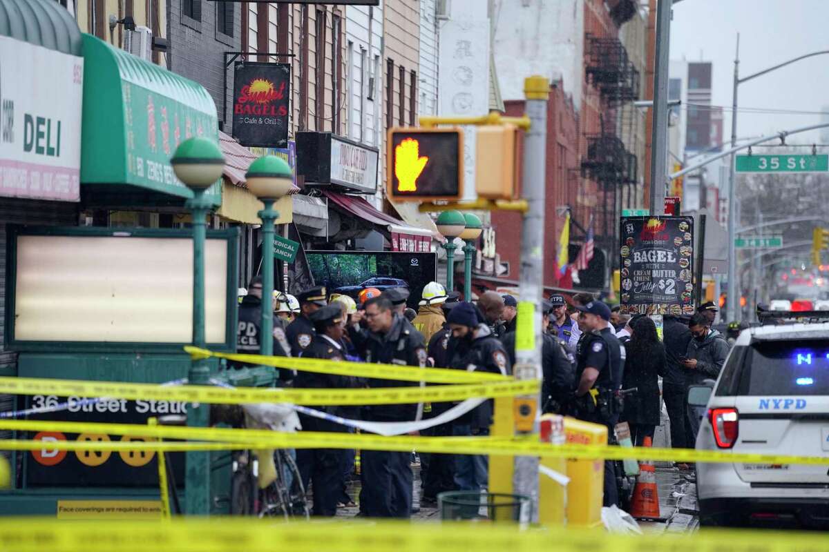 Emergency personnel gather at the entrance to a subway stop in the Brooklyn borough of New York on Tuesday. A gunman filled a rush-hour subway train with smoke and shot multiple people Tuesday, leaving wounded commuters bleeding on a platform as others ran screaming, authorities said.