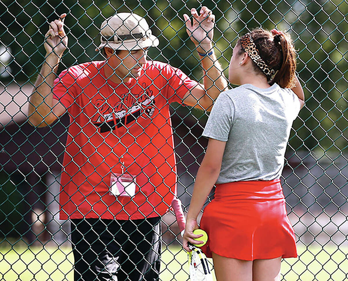 Alton tennis coach Robert Logan (left) talks with Shannon Willis during a match against Metro East Lutheran on Aug. 26, 2015. Logan lost his fight with cancer in 2016 at age 30.