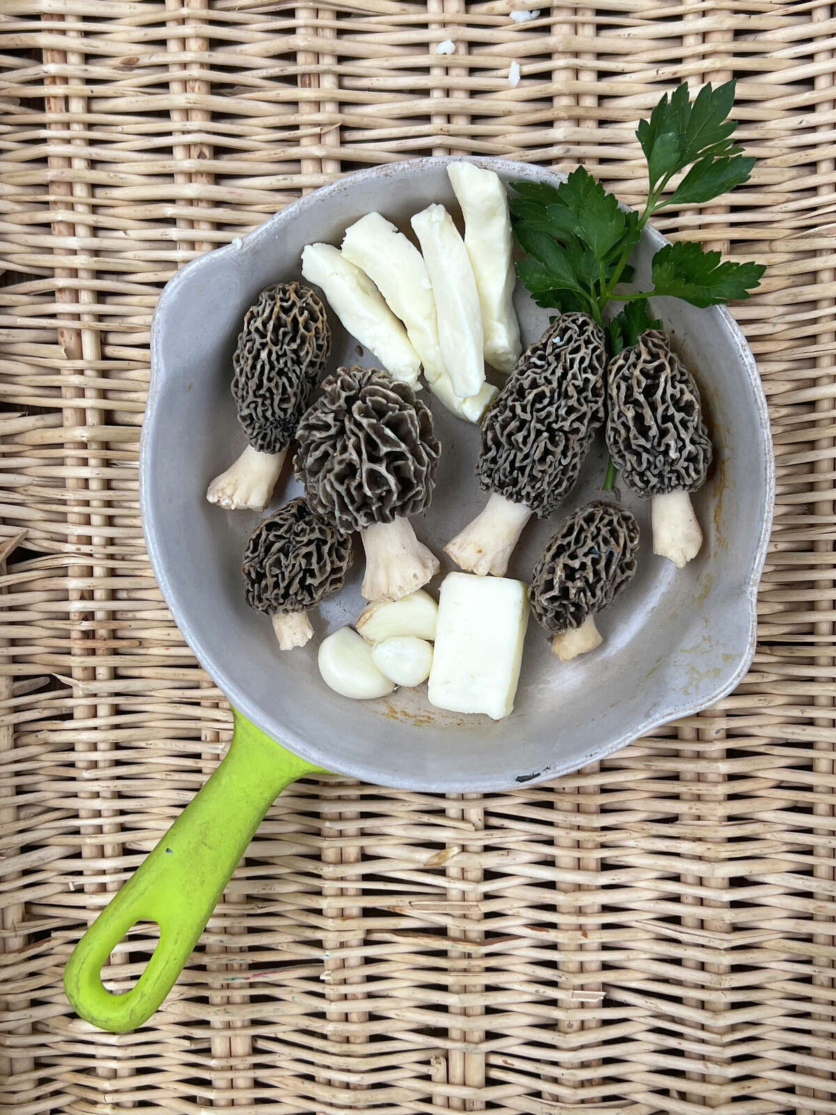 Common morels, known as "yellows," and found by Gary Vondrasek, of Edwardsville, sit in a skillet with garlic, fine cheeses and parsley, which are the ingredients for a scrambled egg morel and garlic brunch recipe. This morel species is one of the most readily recognized of all the edible mushrooms and highly sought.