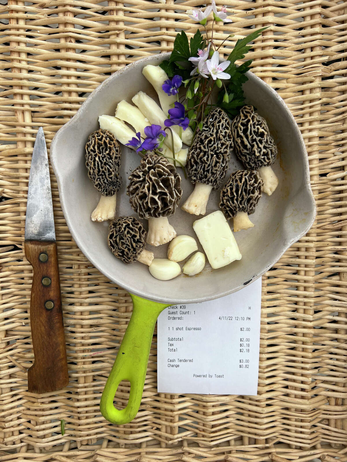 Common morels, known as "yellows," and found by Gary Vondrasek, of Edwardsville, sit in a skillet with garlic, fine cheeses, parsley and edible flowers, which are ingredients for a scrambled egg morel and garlic brunch recipe. Vondrasek's French knife sits beside the skillet. This morel species is one of the most readily recognized of all the edible mushrooms and highly sought.