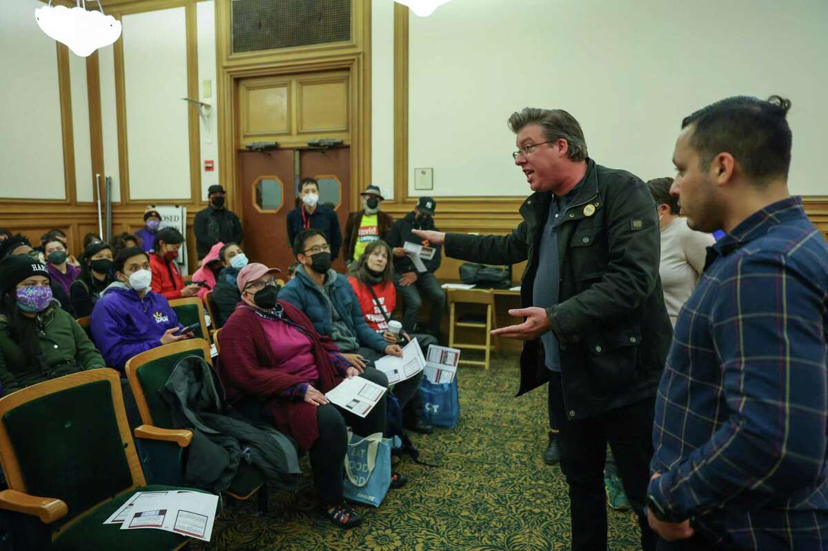Christopher Christensen (second from right) speaks to a group rallying Monday at City Hall against the redistricting of neighborhoods in San Francisco.