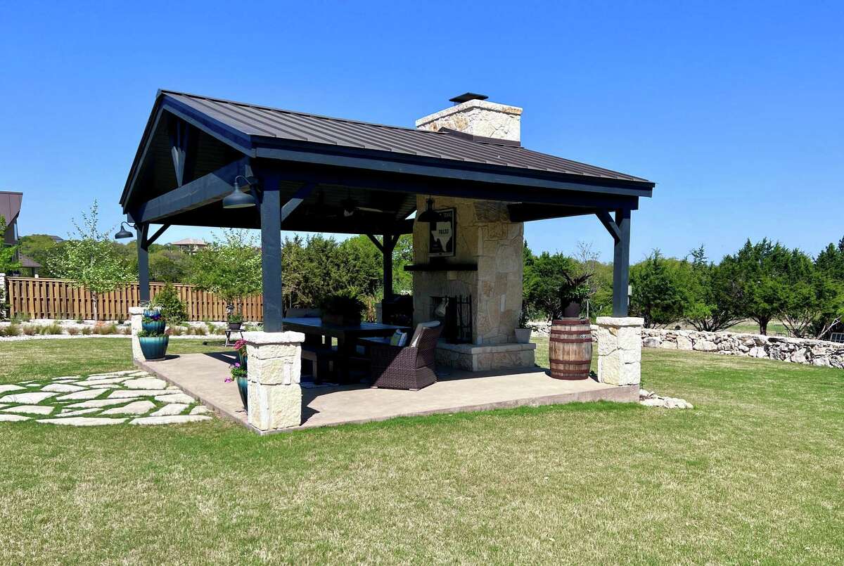 The centerpiece of the backyard is the covered pavilion measuring 18 feet by 24 feet. It has a peaked roof with Douglas fir beams, a tongue-and-groove ceiling and a fireplace with limestone veneer.