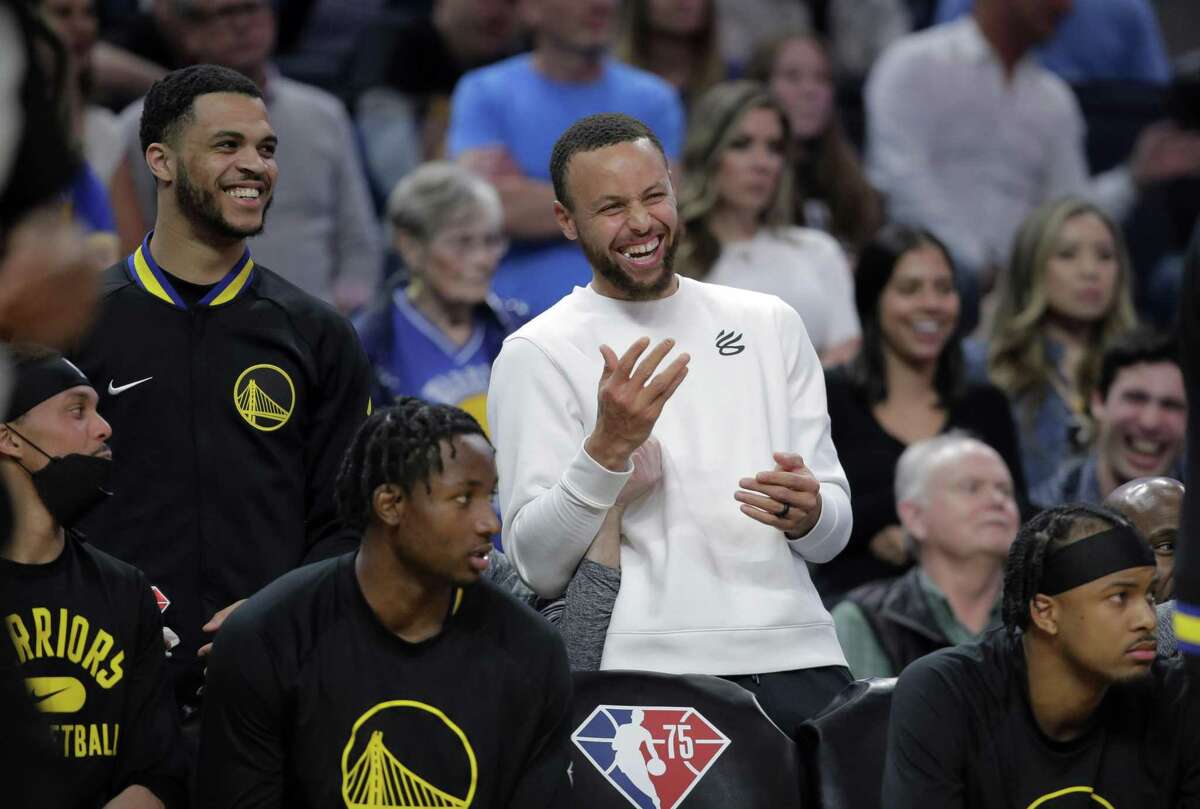 Stephen Curry (30) laughs with teammates on the bench in the second half as the Golden State Warriors played the Phoenix Suns at Chase Center in San Francisco, Calif., on Wednesday, March 30, 2022.