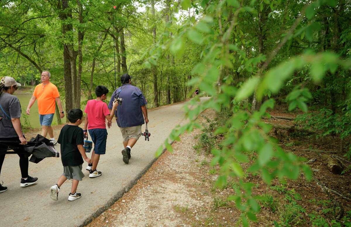 People walk along a trail in Kickerillo-Mischer Preserve, 20215 Chasewood Park Dr., Tuesday, April 12, 2022, in Houston. The Houston Health Department reports today’s tree pollen readings as extremely heavy.