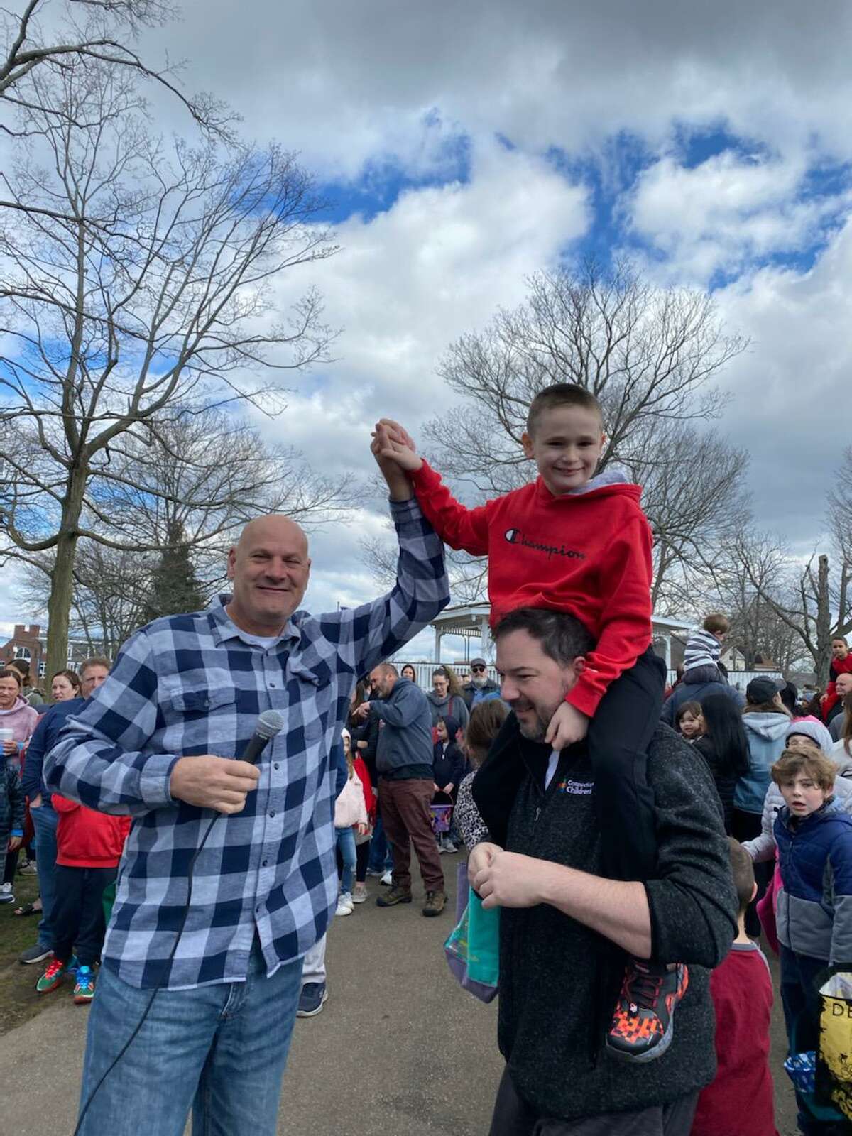 East Haven Mayor Joseph Carfora, left, gives a high-five to one of the children who won airline tickets at Sunday's Easter egg hunt.