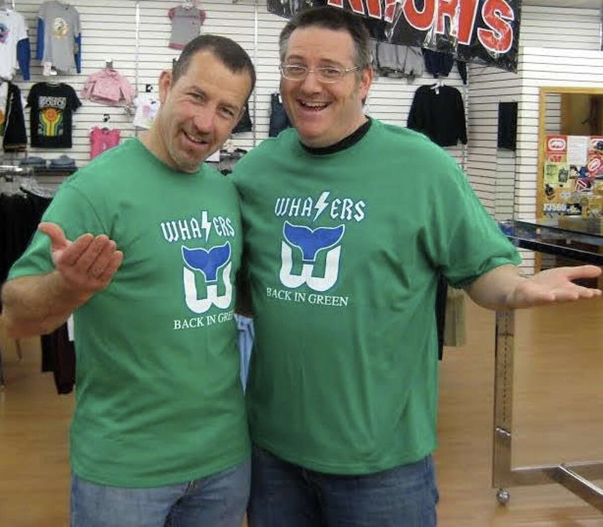 Former Hartford Whalers captain Kevin Dineen, right, stopped in at Dave Schneider’s Bridgeport store, Jimmy’s, 11 years after the last Whalers hockey game, when Dineen was a coach in Portland, Maine. He bought a Whalers T-shirt. Schneider, at right, is “defenseman, guitarist and singer” for the hockey-rock band The Zambonis.