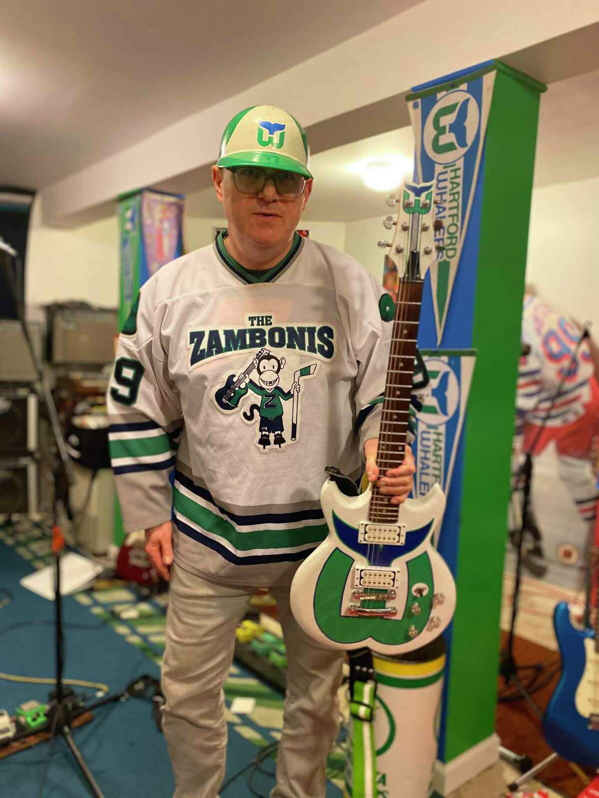 Dave Schneider is “defenseman, guitarist and singer” for the Connecticut-based hockey-rock band The Zambonis. Schneider, owner of Jimmy’s Army and Navy in downtown Bridgeport, created a Hartford Whalers Gibson guitar and wears Whalers gear at every gig.