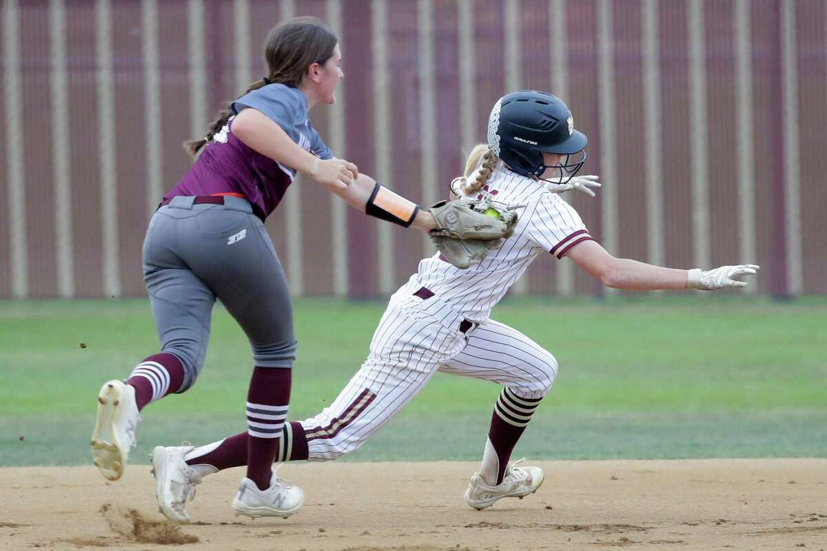 Magnolia shortstop Jade Bubke, left, tags out Magnolia West runner Hailey Toney on a pickle play during the first inning of a high school softball game Tuesday, April 12, 2022 in Magnolia, TX.