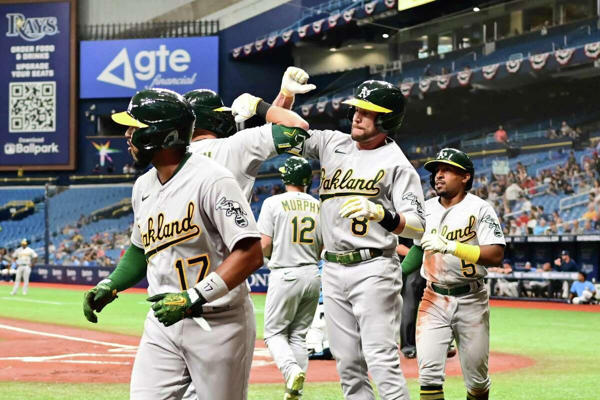 ST PETERSBURG, FLORIDA - APRIL 12: Jed Lowrie #8 celebrates with Seth Brown #15 of the Oakland Athletics after hitting a three-run home run in the first inning against the Tampa Bay Rays at Tropicana Field on April 12, 2022 in St Petersburg, Florida. (Photo by Julio Aguilar/Getty Images)