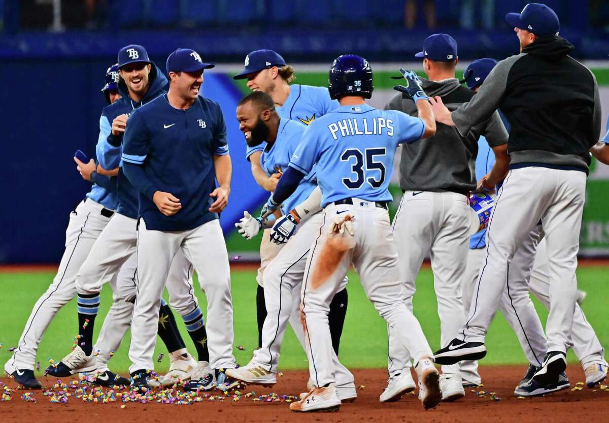 ST PETERSBURG, FLORIDA - APRIL 12: Manuel Margot #13 of the Tampa Bay Rays celebrates with teammates after hitting an RBI walk-off single in the 10th inning for a 9-8 win over the Oakland Athletics at Tropicana Field on April 12, 2022 in St Petersburg, Florida. (Photo by Julio Aguilar/Getty Images)